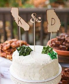 a white cake with two wooden signs on top