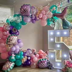 the letter f is made out of balloons and mermaid tailes, along with other decorations