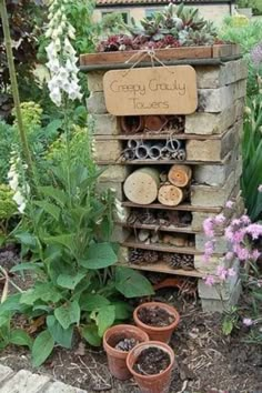 a garden with lots of potted plants and flowers in the ground next to a sign that says, crazy creativity towers