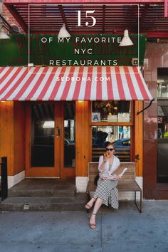 a woman sitting on a bench in front of a restaurant with red and white striped awning