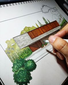 someone is drawing a house with colored pencils