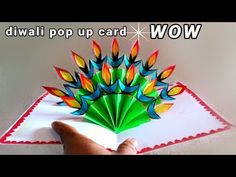 a hand is holding an origami card with colorful flowers on it and the words diwali pop up card wow