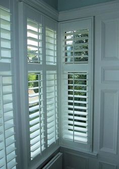 an empty room with white shutters on the windows