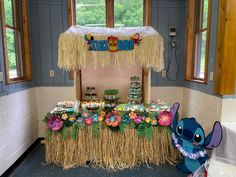 a tiki bar decorated with grass, flowers and lili - pooh decorations