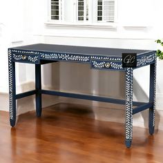 a blue table with two drawers on top of it in front of a white wall