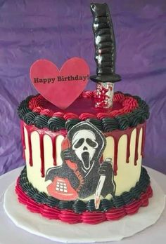 a decorated birthday cake with a knife and skull on it's top, sitting on a table