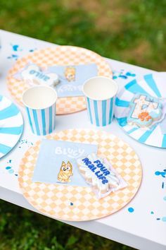 a table topped with paper plates and cups