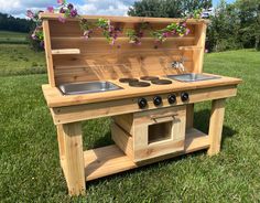 an outdoor kitchen made out of wooden pallets with sink and stove in the middle