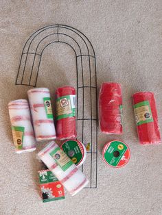 several rolls of toilet paper sitting on the floor next to a wire rack with four rolls of toilet paper