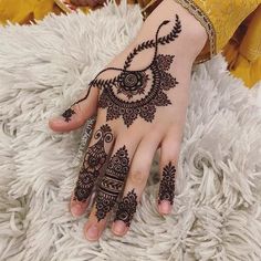 a woman's hand with henna tattoos on it