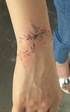 a woman's foot with a flower tattoo on it