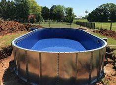 an above ground swimming pool in the middle of a yard with dirt and grass around it