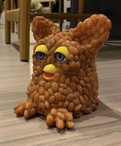 a plastic bear made out of peanuts sitting on the floor