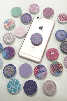 a cell phone surrounded by many different colored donuts on a white surface with the iphone in the middle