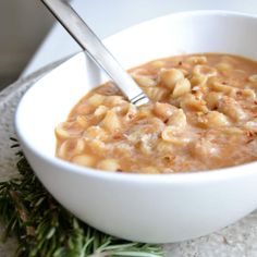 a white bowl filled with macaroni and cheese soup on top of a table