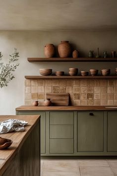 a kitchen with green cabinets and wooden counter tops