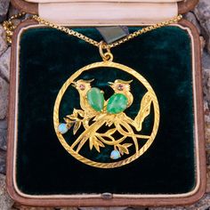 This detailed vintage circle pendant features pierced and engraved birds with pear jade accents as the body of the bird. The pendant also featured opal cabochons and lab created pink sapphires. It hangs on a new 18" rounded box chain. The necklace is crafted in 14k yellow gold. Elegant Bird Design Jewelry For Anniversary, Vintage Jade Round Pendant Jewelry, Collectible Yellow Gold Jade Jewelry, Yellow Gold Bird Design Pendant Jewelry, Gold Round Jewelry With Bird Design, Old Boxes, Aquamarine Rings, Circle Pendant, March Birth Stone