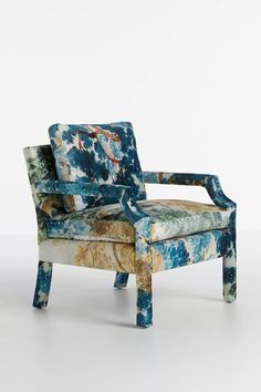 an upholstered chair with blue and green paint on it's back, in front of a white background