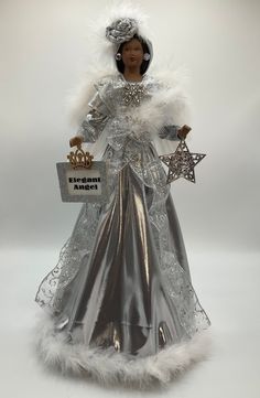 a barbie doll dressed in silver and wearing a tiara with stars on it's head