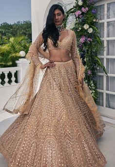 Illuminate the occasion in this gold mirror and zardozi embroidered tulle lehenga, perfectly paired with an embroidered full sleeve blouse featuring delicate feather detailing. Complete the look with a tulle dupatta adorned with embroidery and a feather border, creating a stunning ensemble that captures both opulence and grace. Tulle Lehenga, South Asian Outfits, Outfits For Wedding, Gold Organza, Gold Lehenga, Full Sleeve Blouse, Fashion Illustrations Techniques, Bead Crochet Patterns, Indian Inspired