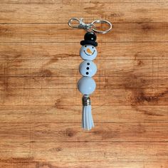 a key chain with a snowman wearing a top hat and tassel on it