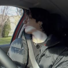 a woman sitting in the passenger seat of a car with her head out the window