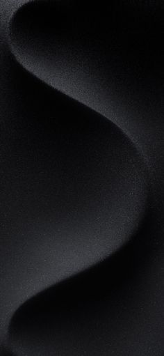 an abstract black background with smooth lines and curves in the center, as well as wavy fabric