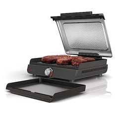 an electric grill with two hamburger patties on it