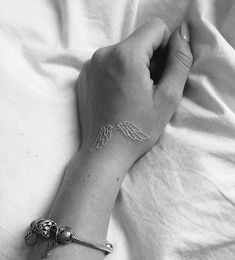 black and white photo of a person's arm with an angel tattoo on it