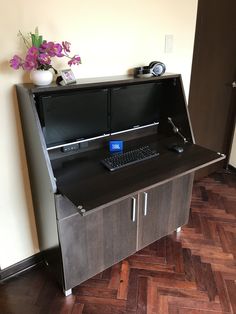 a computer desk with a keyboard and mouse on it in front of a flower vase