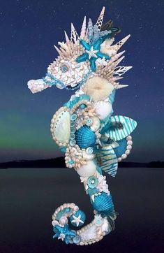 a seahorse made out of seashells and other items in the night sky