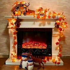 a fireplace decorated with fall leaves and decorations