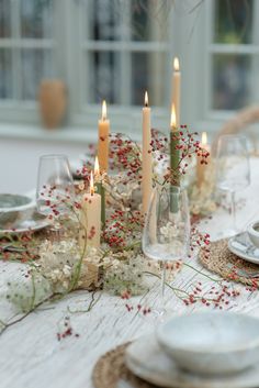 the table is set with candles and plates