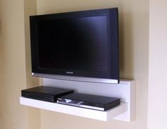 a flat screen tv sitting on top of a white shelf