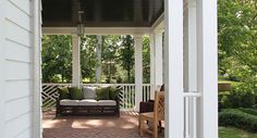 a porch with a couch and chairs on it