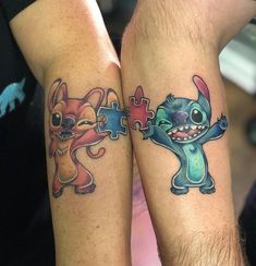 two people with matching tattoos on their arms holding each other's hands and one has a puzzle piece in the shape of a dog