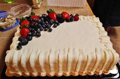 a cake with white frosting and berries on top