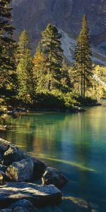 a lake surrounded by trees and rocks in the mountains