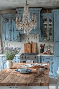 a kitchen with blue cabinets and a chandelier hanging from the ceiling