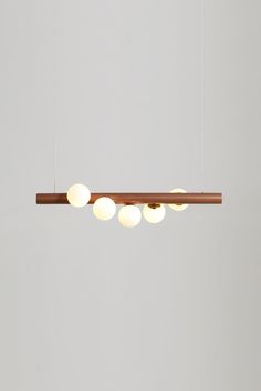 an overhead light fixture with five lights hanging from it's sides and two wooden poles