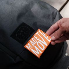 a person is holding an orange and black patch