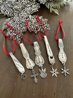 christmas ornaments are laid out on a table with red ribbon and decorations in the shape of snowflakes