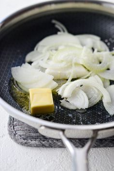 onions and butter are being cooked in a frying pan