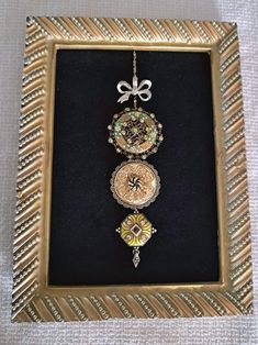 an ornate gold frame holds a watch and brooches