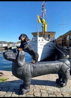 a statue of a dog on its hind legs in front of a boat