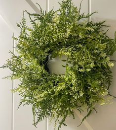 a green wreath hanging on the side of a door