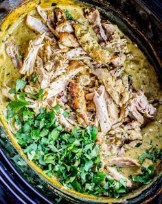 chicken and parsley in a yellow sauce on top of a black stovetop oven