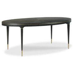 an oval dining table with gold trimmings and black woodgrain, on a white background