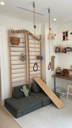 a living room filled with furniture and hanging items on the wall next to a couch