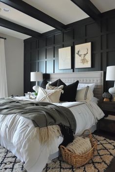 Elegantly styled bedroom with a black accent wall, white bedding, and decorative pillows, featuring dark wood ceiling beams and artwork above the bed. Bad Inspiration, Bad Design, White Bedroom, Bedroom Themes